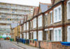 Traditional English terraced houses with huge council block in the background in south east London