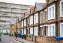 Traditional English terraced houses with huge council block in the background in south east London