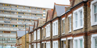 Traditional English terraced houses with huge council block in the background in south east London