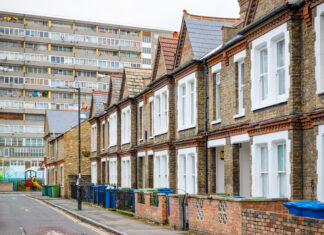 Traditional English terraced houses with huge council block in the background in south east London