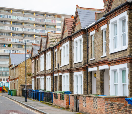 Traditional English terraced houses with huge council block in the background in south east London