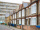 Traditional English terraced houses with huge council block in the background in south east London